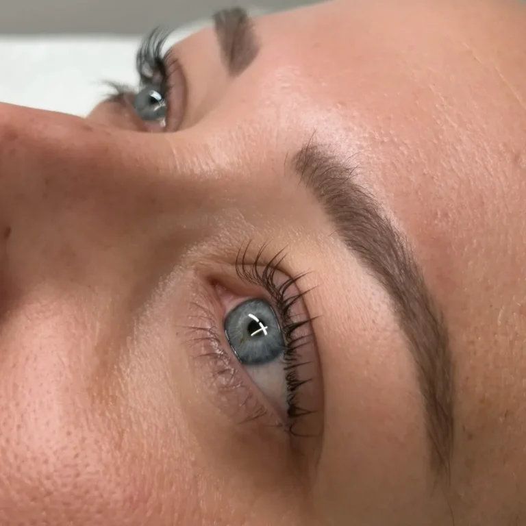 Close-up of blue eyes and groomed eyebrows.