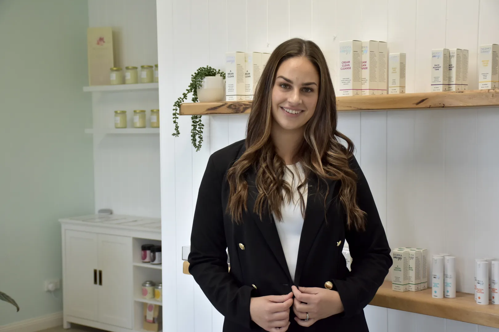Woman in store with skincare products on shelves.