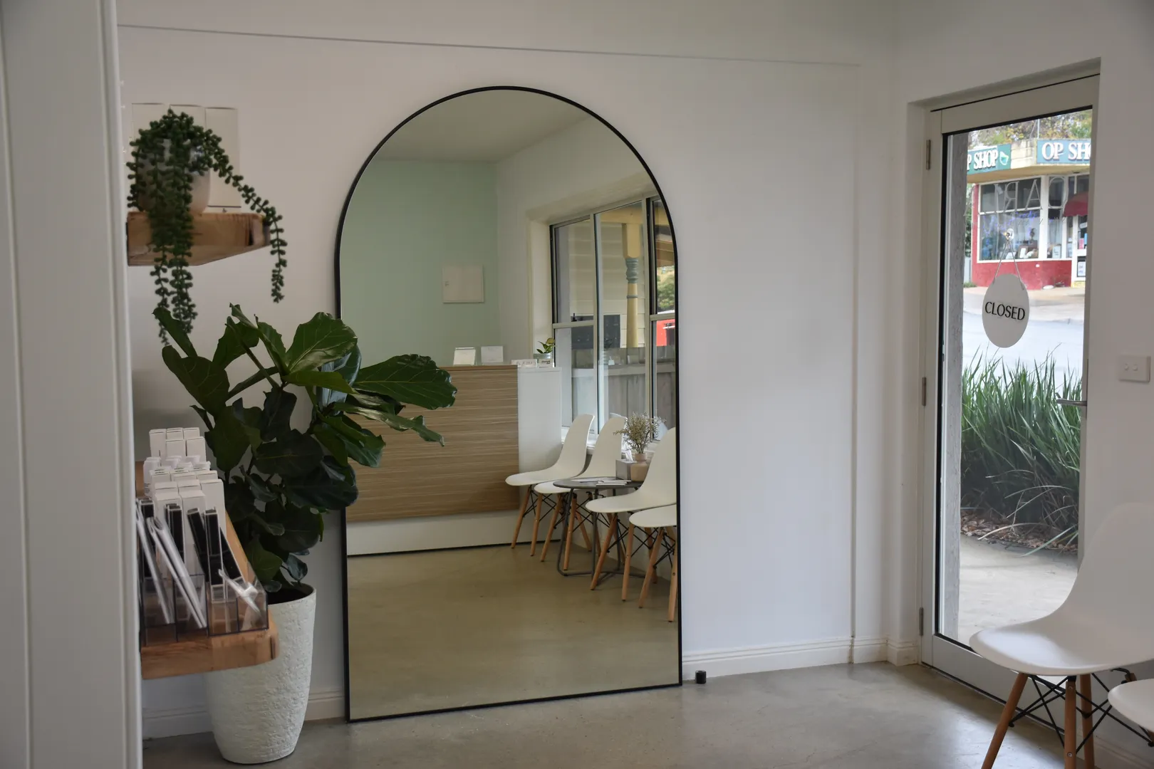Modern waiting room with large mirror and plants.